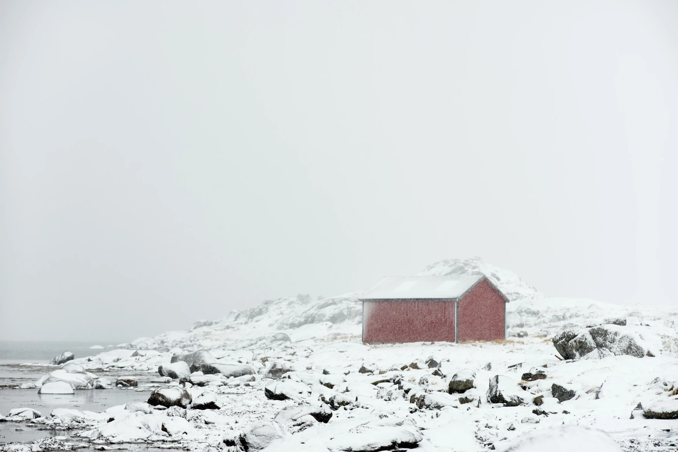 a barn on the shore covered in snow