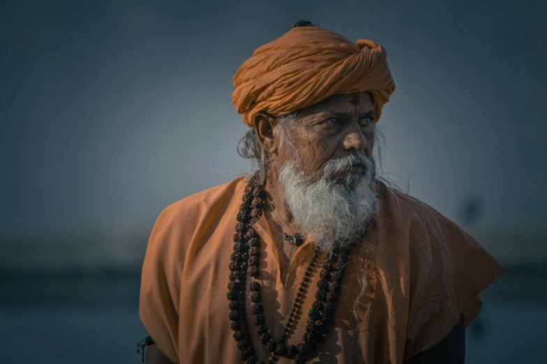 an old man with beard in an orange turban