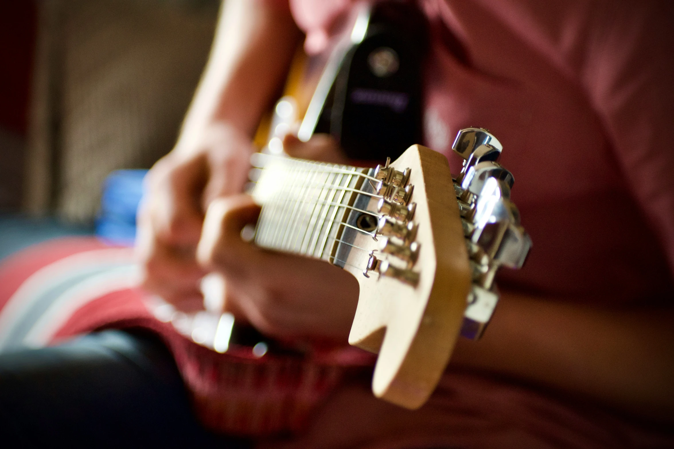 the man is playing the guitar and adjusting his fret