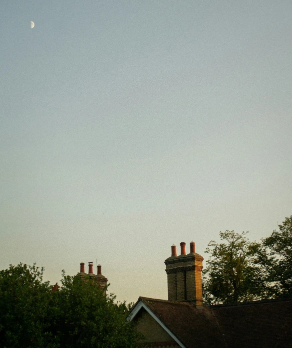 the moon and some clouds above buildings