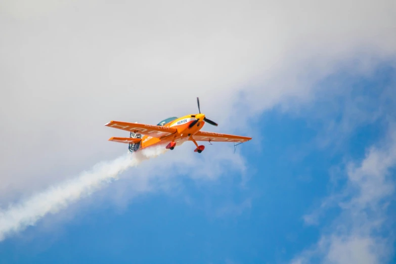 an airplane is flying with a smoke trail on its nose