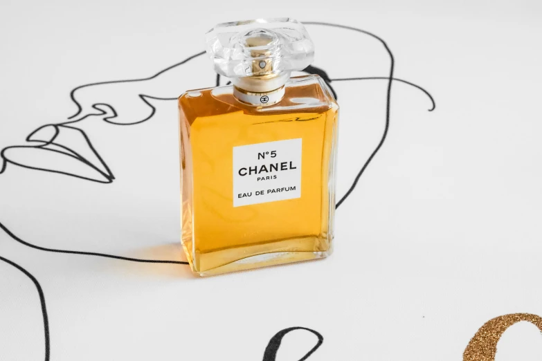 a glass bottle of orange colored perfume