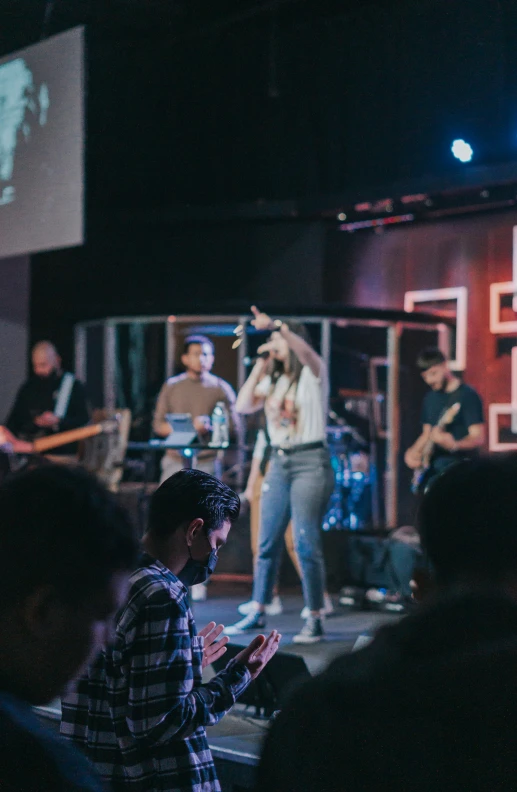 a group of people playing instruments while standing on a stage