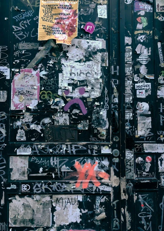 a wall covered with stickers and graffiti on it