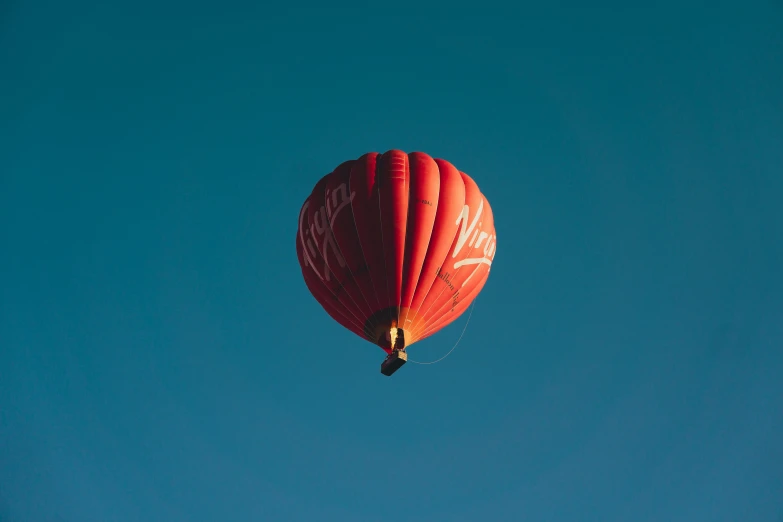 a red balloon floats high into the air