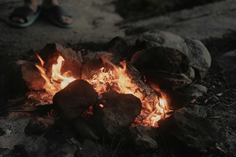 a person sitting by a fire in the dirt
