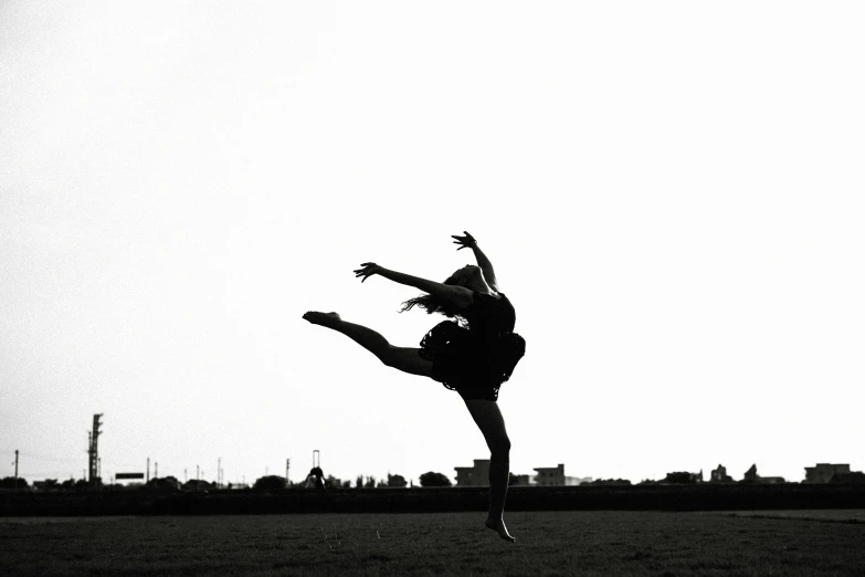 black and white pograph of woman doing an aerial kick