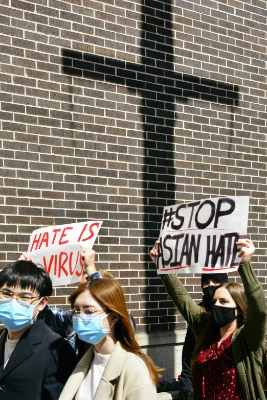 three people standing around each other holding up signs