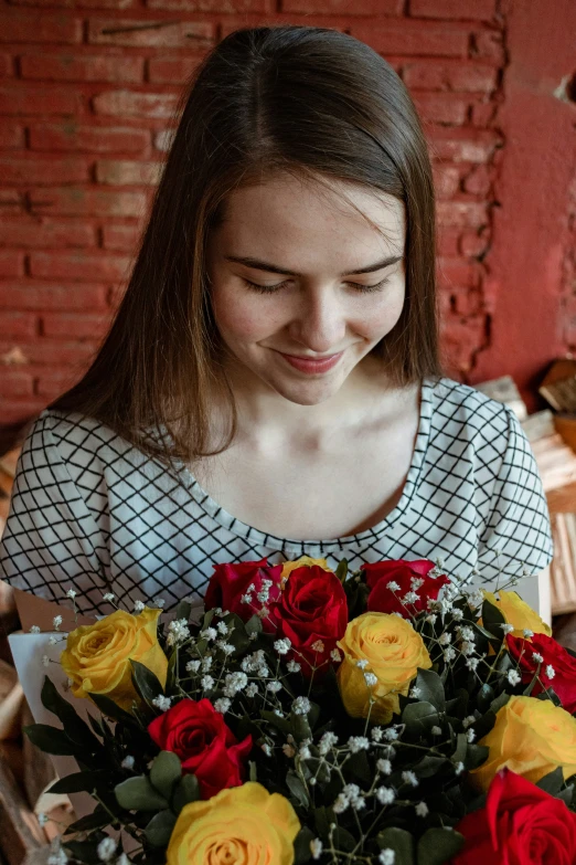 a smiling girl holding a bunch of colorful roses