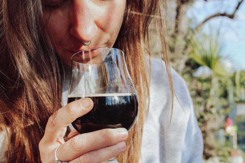 a woman smelling a wine glass in her left hand