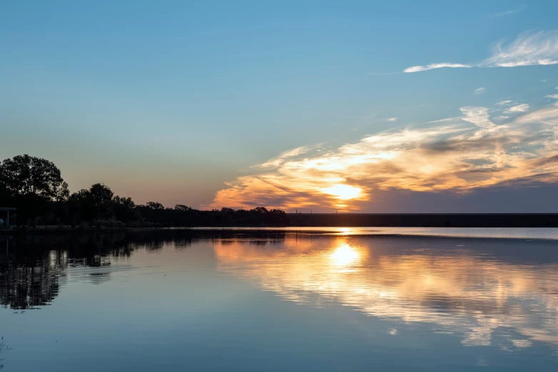 a sunset over some water on a sunny day