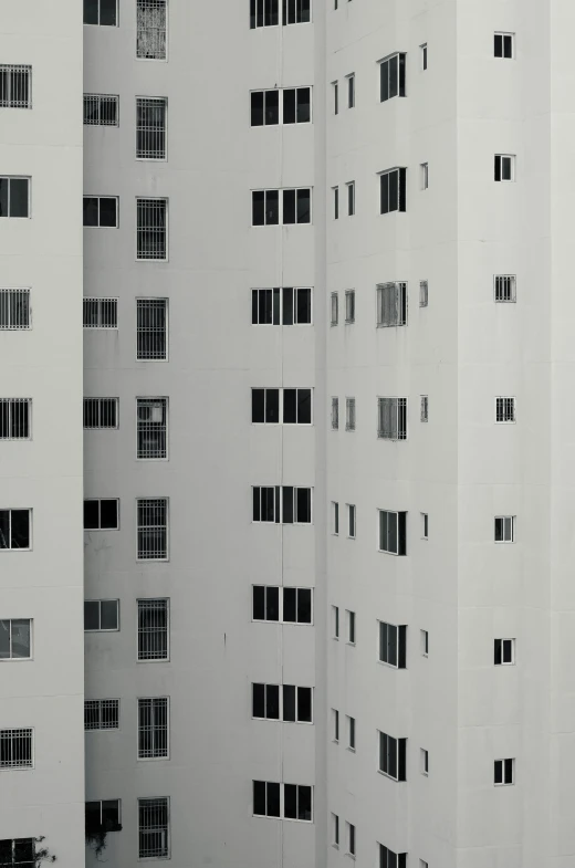 a tall white building has multiple windows that appear to be filled with sunlight