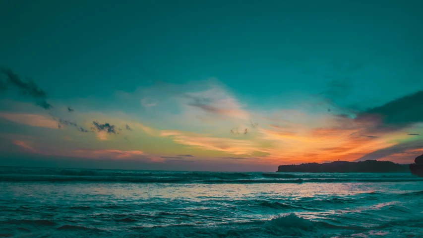 a person riding a surfboard at sunset on the ocean