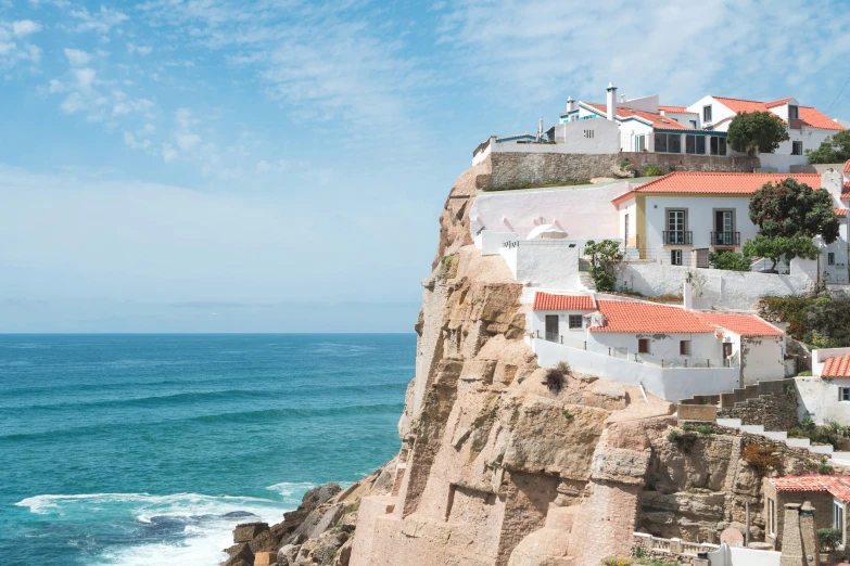 a building on the cliff overlooks the water