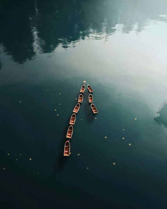 three canoes are sitting in the water, facing each other