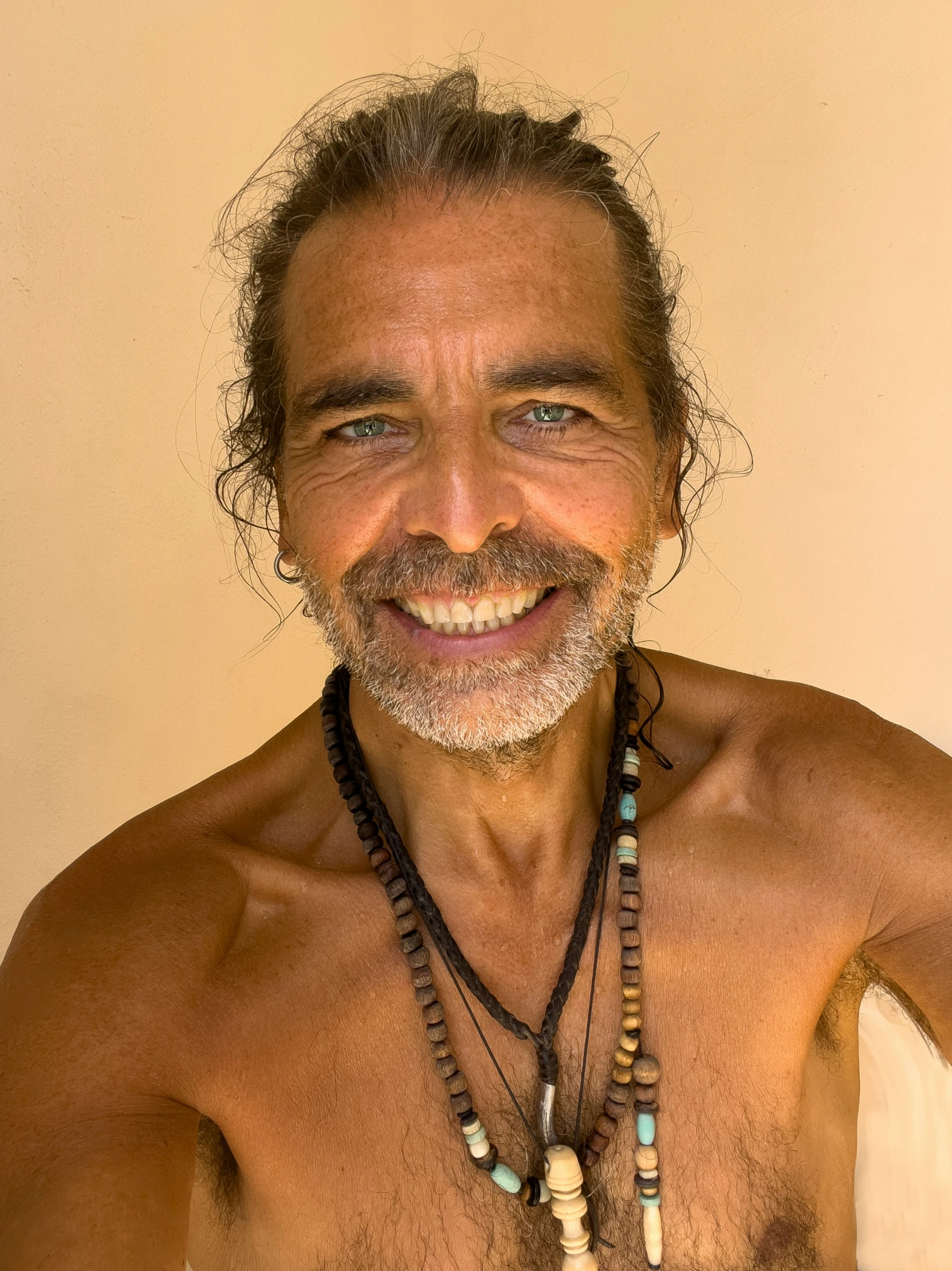 a man with a white beard and necklaces