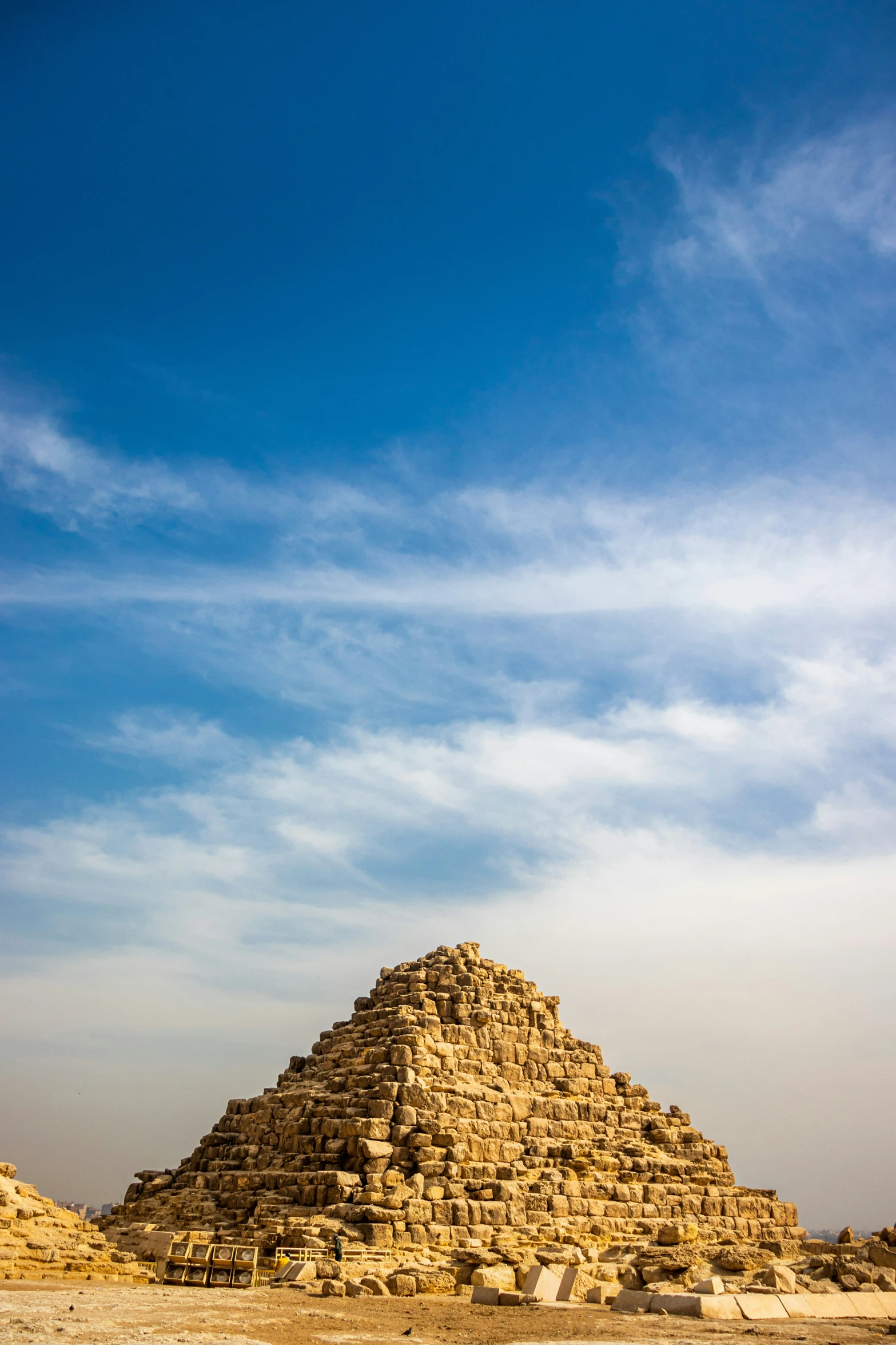 a pyramid made of sand with blue skies above it