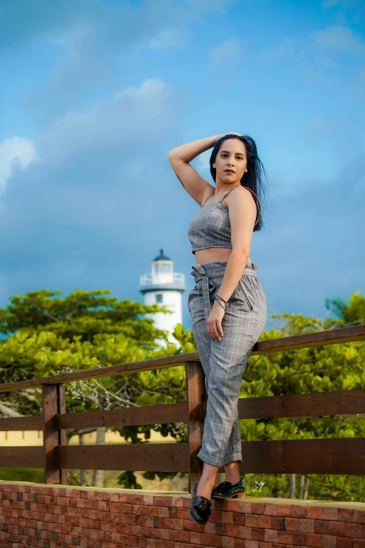 a young woman with dark hair, wearing a crop top and jeans