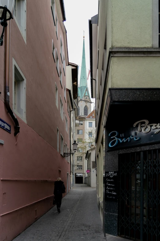 a person walks down an alley way towards some old buildings