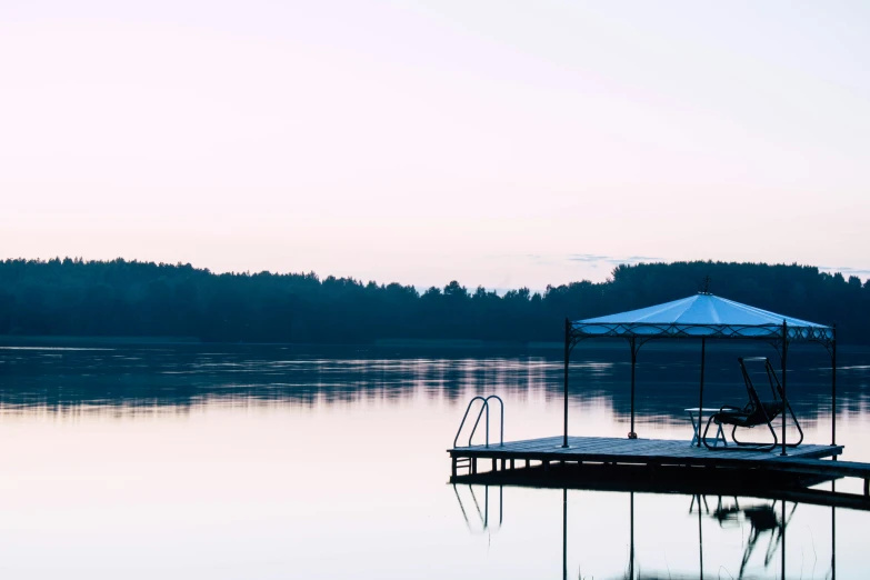 a pier on a lake near a large forest