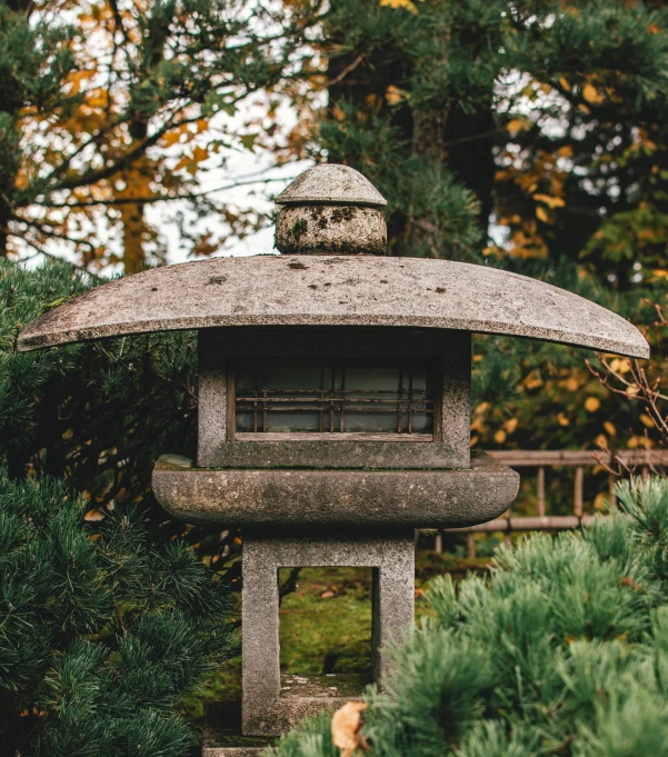 a stone lantern in a garden at a japanese shrine