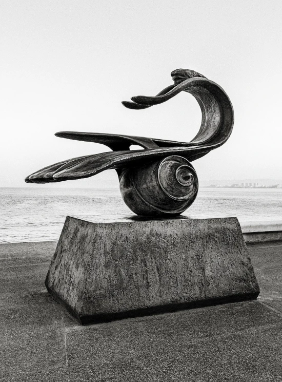 a statue of a bird on top of the sand