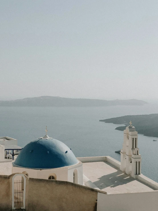 two large white domes sit above the ocean