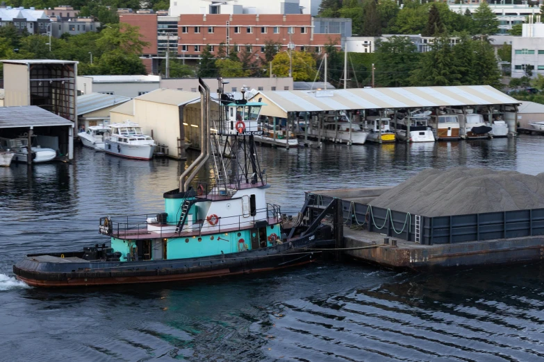 a tug boat is docked next to an old shed