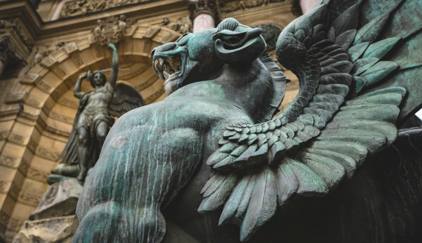 a large statue of a bird on the top of a building