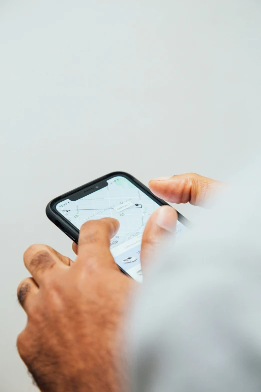 a man holding an iphone while looking at it