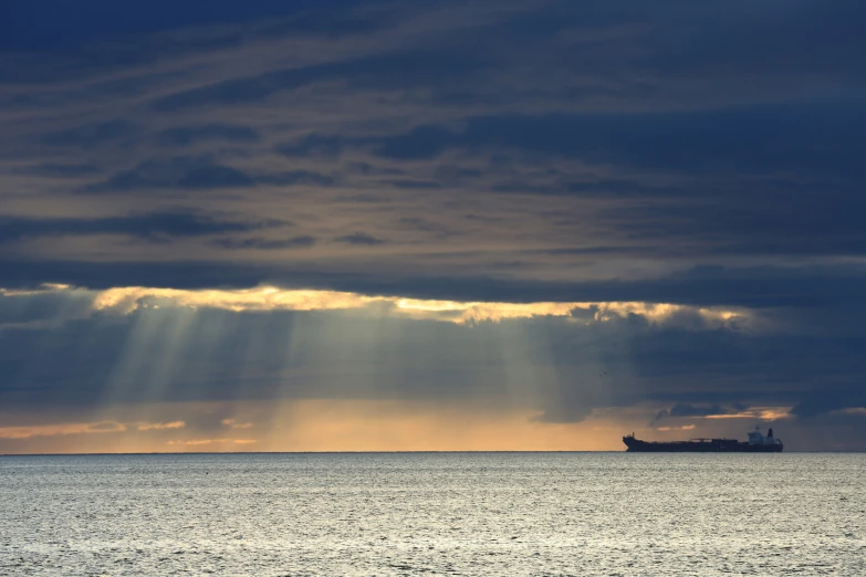 a sunbeam over the ocean and a big ship