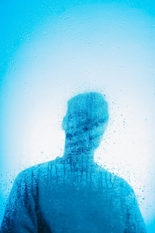 a person in a silhouetted image is in front of a very bright blue background