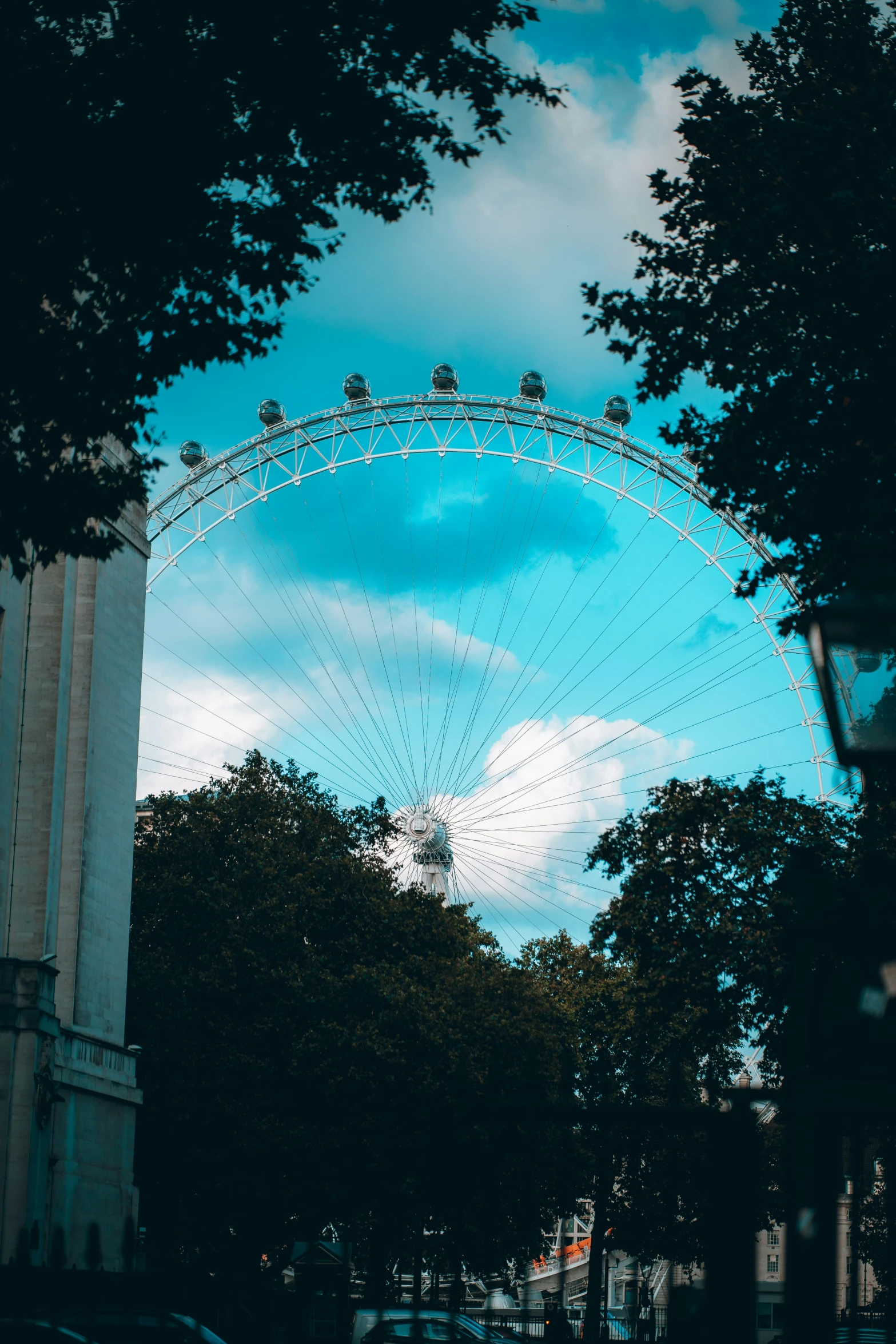 a ferris wheel behind a building on a street