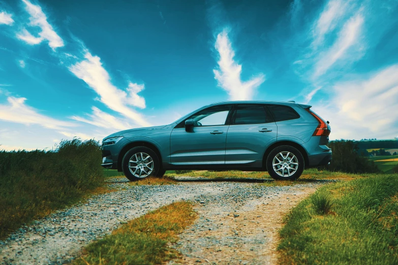 the grey suv is parked on a gravel road