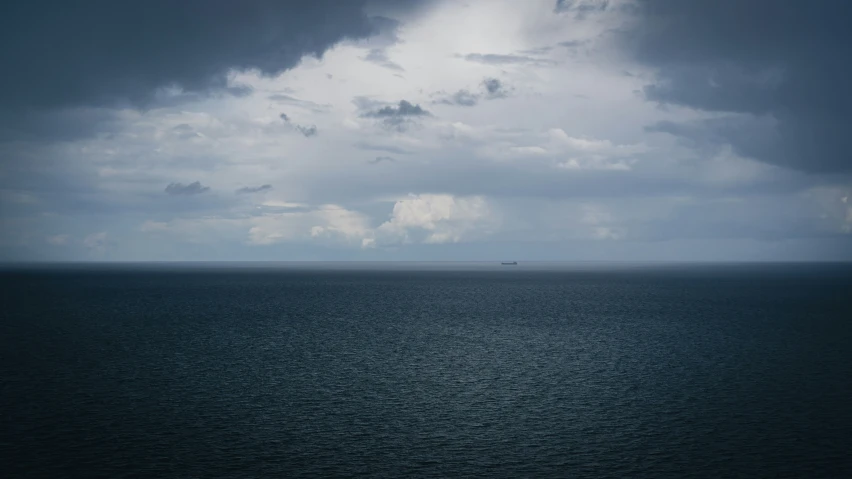 there is a boat in the water under a cloudy sky