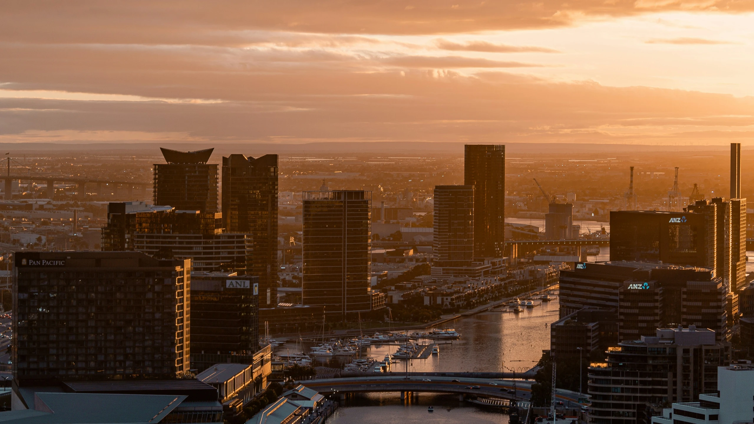 the city skyline with buildings in a harbor area at sunset