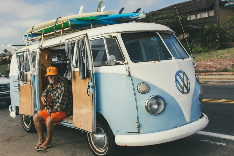 a person standing next to a van that has surfboards on it