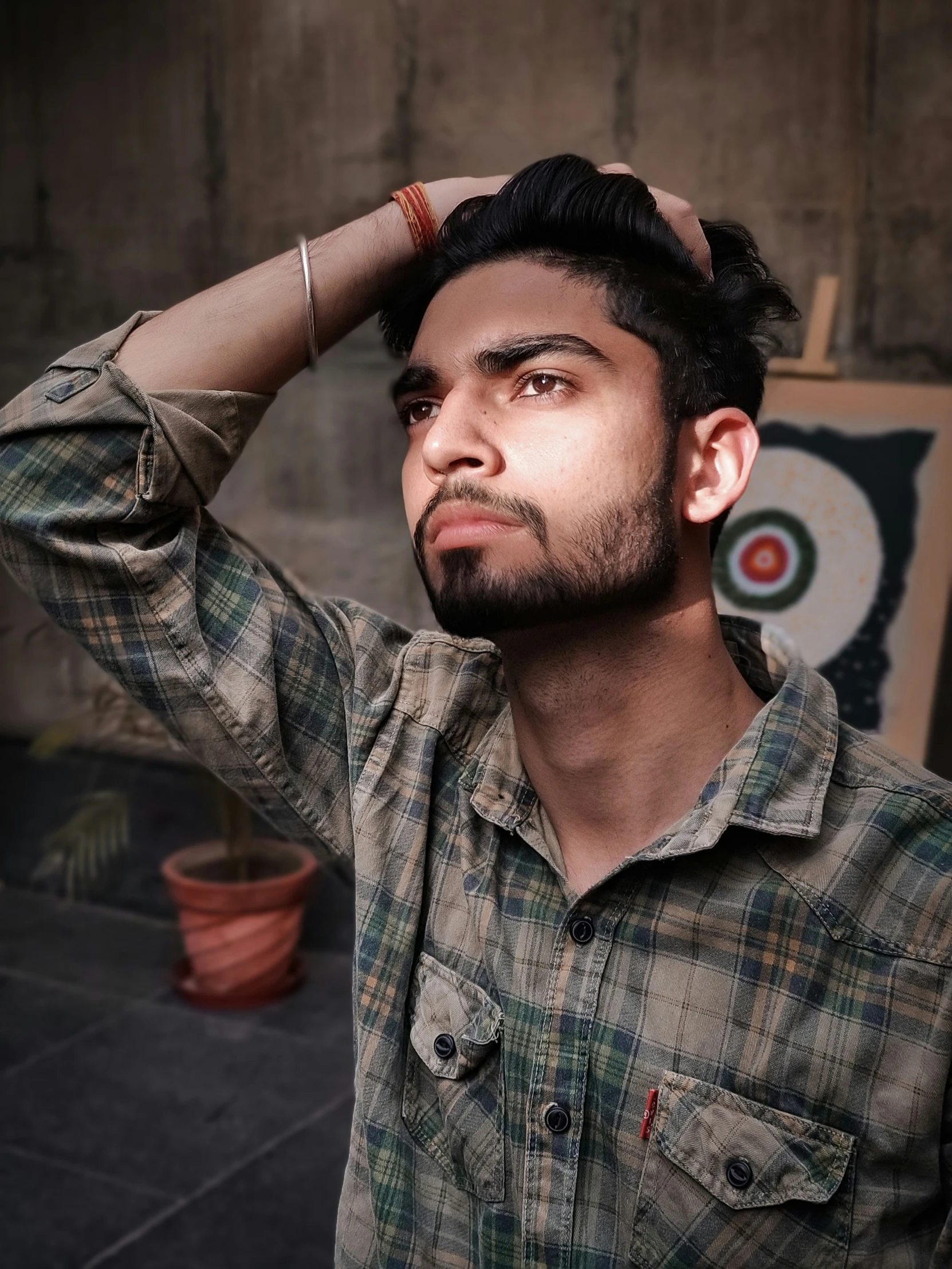 a man who is holding his head up to his hair