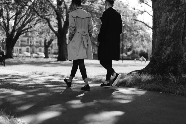 two people walking through a park holding hands