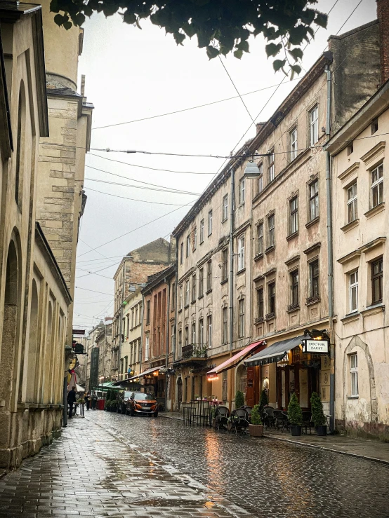 a wet city street with buildings and an umbrella