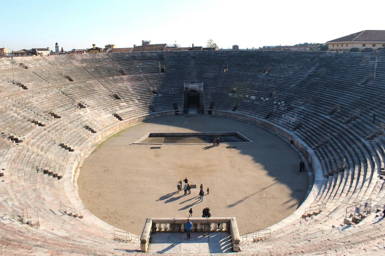 people are standing inside a massive, concrete stadium