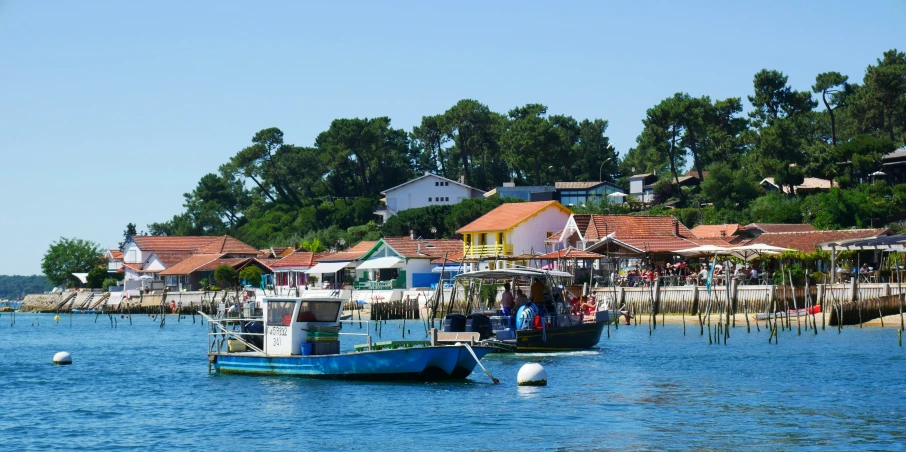 a body of water filled with boats next to a village