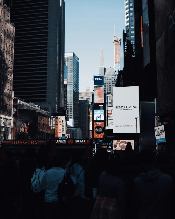 a group of people stand outside on the sidewalk