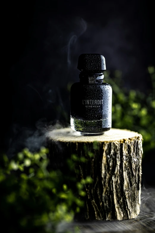 a bottle on top of a log with smoke