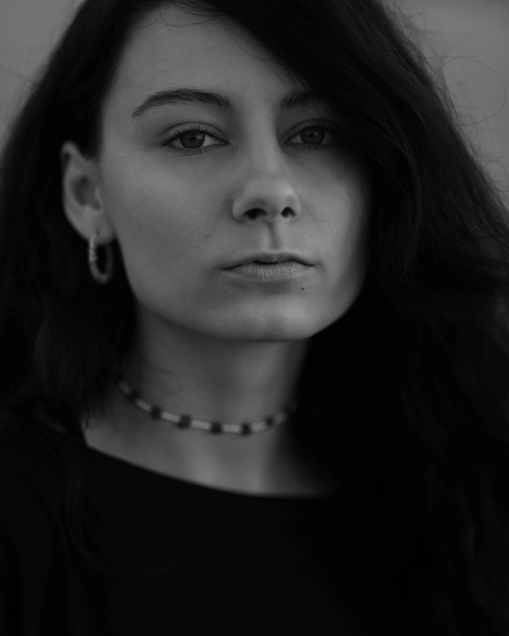 a woman is looking over her shoulder while wearing a necklace