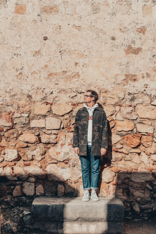 a person standing next to a brick wall