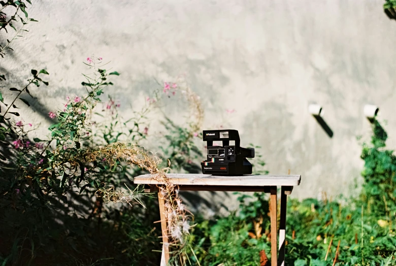 a camera sitting on top of a wooden table in the grass