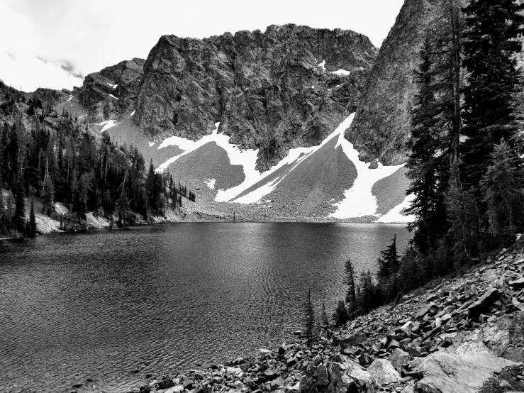 a large body of water near mountains in black and white