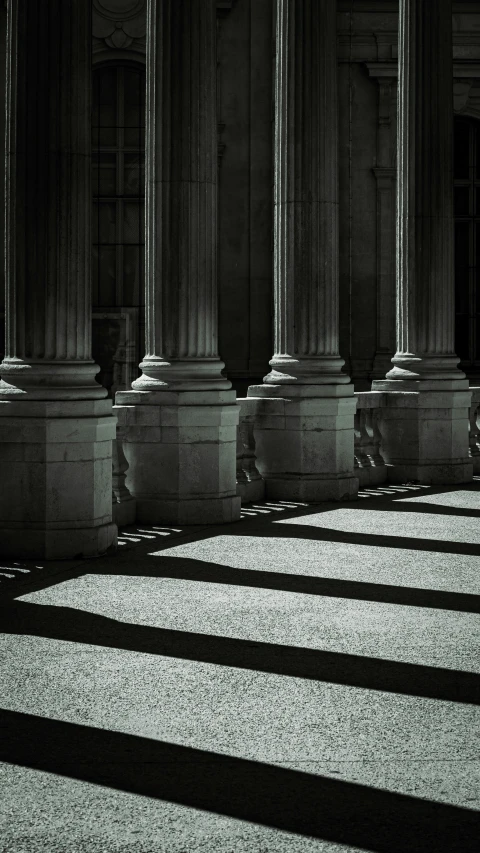 the columns of a building are casting long shadows