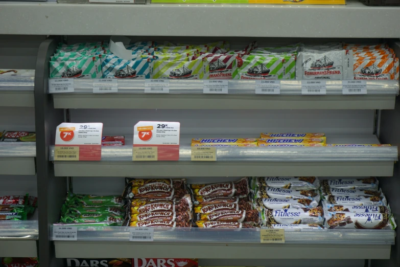 an aisle in a grocery store with packets and bags of candy